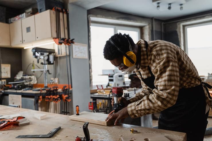 Tradesperson wearing ear protection working at a bench in a construction workshop