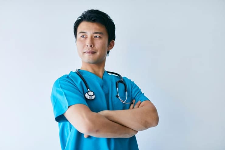 Nursing professional in scrubs with a stethoscope, arms folded